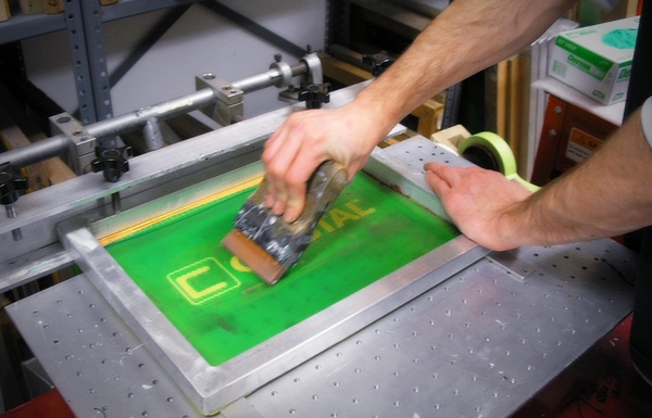 An employee of United Plating performing silkscreening